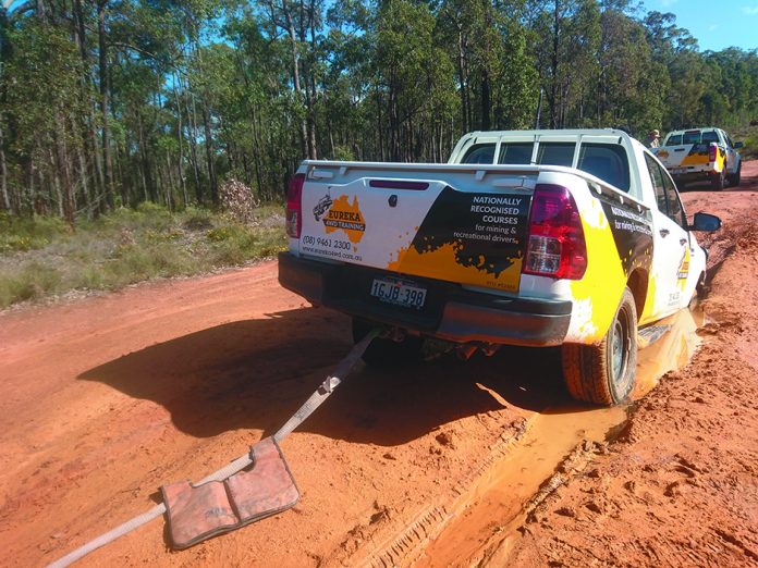 A 4WD which has driven into a gutter on the side of the road