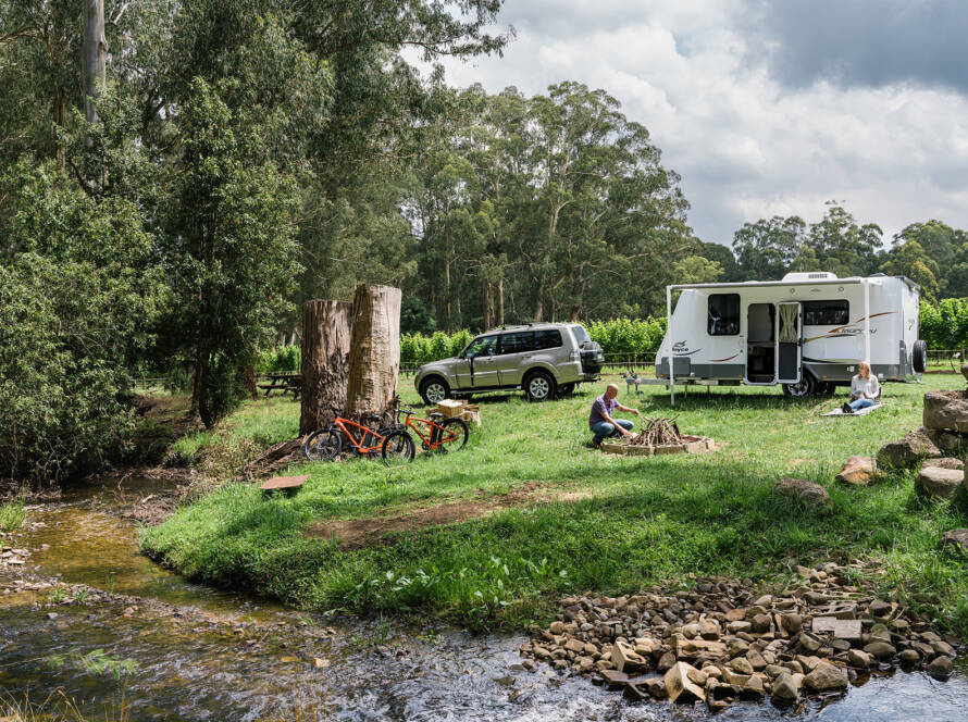 A family setting up a campfire in front of their caravan