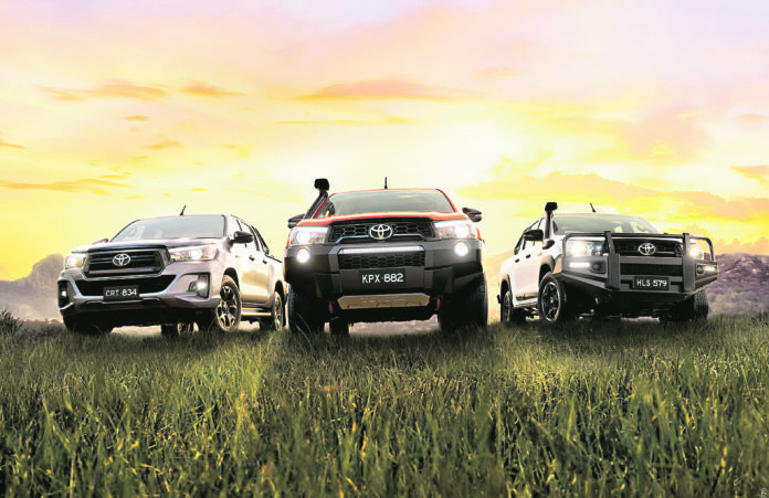 Three Toyotas in a grassy field