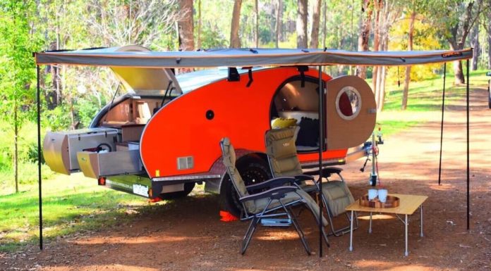 A handmade camper set up in a forest from Cool Beans